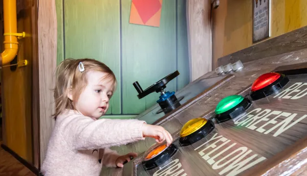 Toddler pressing buttons in Mr Bouncer's Invention Workshop
